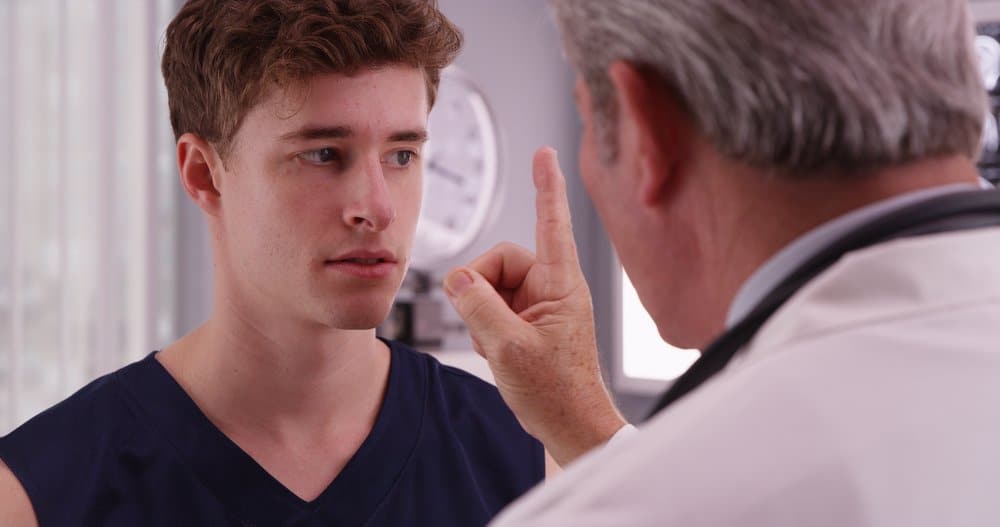 Teen following eyes to doctor's moving finger.