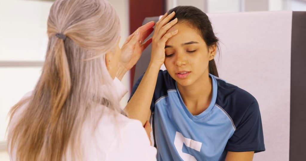 A young soccer player with a head injury recieves medical attention.