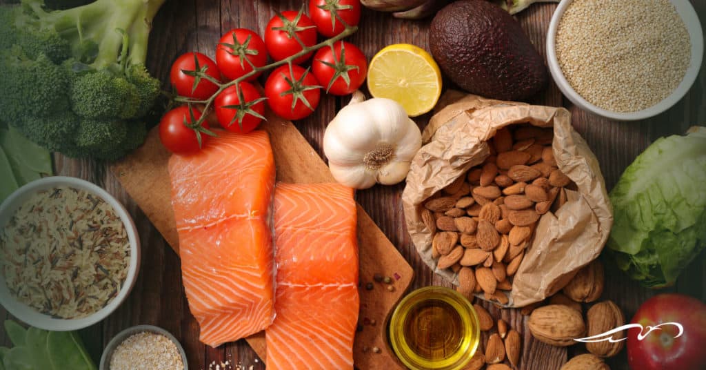 Table of foods including salmon, garlic, olive oil, almonds, avacado, and more.