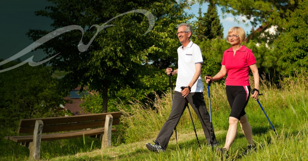 Senior couple partaking in Nordic walking.